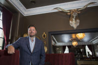 In this Feb. 11, 2020, photo, Brent Frederick, founder of Jester Concepts, a restaurant group in Minneapolis poses at P.S. Steak. Frederick puts a 3% voluntary surcharge on guest checks to help pay for health insurance and mental health services and says almost all guests agree to pay it. (AP Photo/Andy Clayton-King)