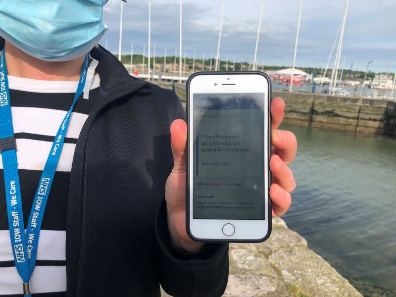 UK National Health Service employee Anni Adams shows a smartphone displaying the new NHS app to trace contacts with people potentially infected with the coronavirus disease (COVID-19) being trialled on Isle of Wight