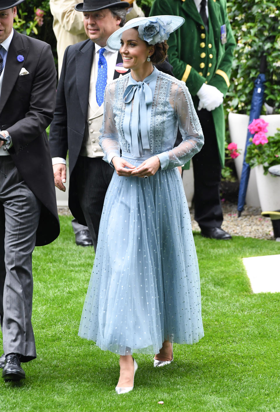 The Duchess of Cambridge debuted a new powder blue Elie Saab ensemble with sheer sleeves and pussy-bow detailing for day one of Royal Ascot with a Philip Treacy floral hat, metallic heels and her Kiki McDonough topaz earrings. [Photo: PA]