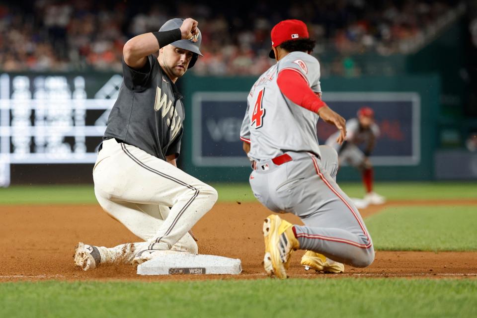 Nationals outfielder Lane Thomas steals third base ahead of a tag by Reds third baseman Santiago Espinal during the seventh inning, July 20, 2024, in Washington, D.C.