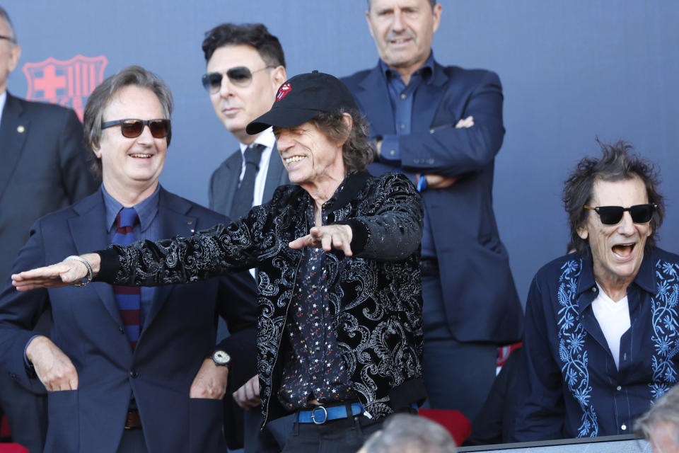 Mick Jagger, centre, and Ronnie Wood, right, of the band "The Rolling Stones," seen prior to the La Liga soccer match between Barcelona and Real Madrid at the Olympic Stadium in Barcelona, Spain, Saturday, Oct. 28, 2023. (AP Photo/Joan Monfort)