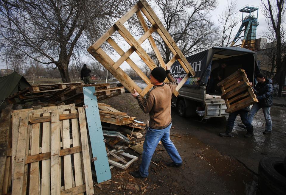 Pro Russian activists collect woods in their camp near the armory Ukrainian army, where they stand to prevent the export of arms and ammunition in the village of Poraskoveyevka, eastern Ukraine, Thursday, March 20, 2014. The disheveled men barricading the muddy lane leading into a military base in this eastern Ukraine village say they're taking a stand to defend Russian-speakers. (AP Photo/Sergei Grits)