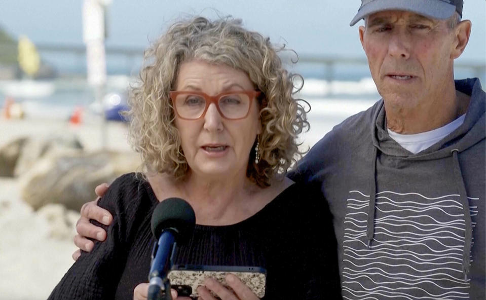 In this image taken from video, Australia's Debra Robinson with her husband Martin, address the media on the beach in San Diego, Tuesday, May 7, 2024 following the deaths in Mexico of their two sons during a surfing trip. The sons, Callum and Jake, and U.S. friend Jack Carter Rhoad, were allegedly killed by car thieves in Baja California, across the border from San Diego, somewhere around April 28 or 29. (Channel 9/POOL via AP)
