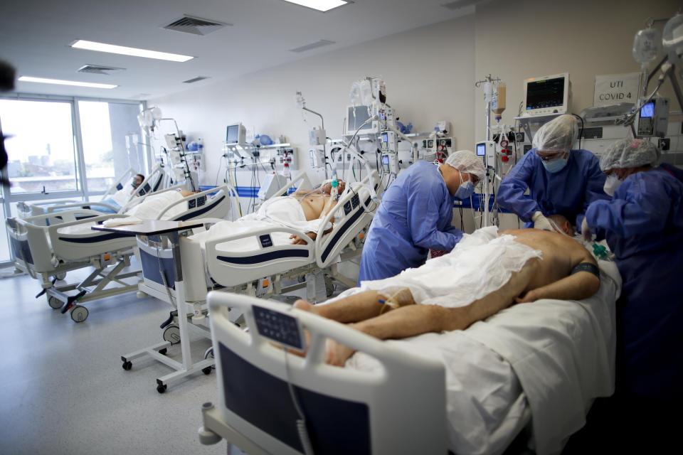 Trabajadores sanitarios atienden a un paciente de COVID-19 en el Hospital Llavallol Dr. Norberto Raúl Piacentini en Lomas de Zamora, a las afueras de Buenos Aires, Argentina, el viernes 23 de abril de 2021. La situación en el Hospital Llavallol. un pequeño centro médico municipal, se replica en muchos establecimiento públicos y privados de Buenos Aires y localidades cercanas, con un promedio de más de 20.000 contagios y 400 fallecidos por día en las últimas semanas y una ocupación de terapias intensivas de algunos centros al 100%. (AP Foto/Natacha Pisarenko)