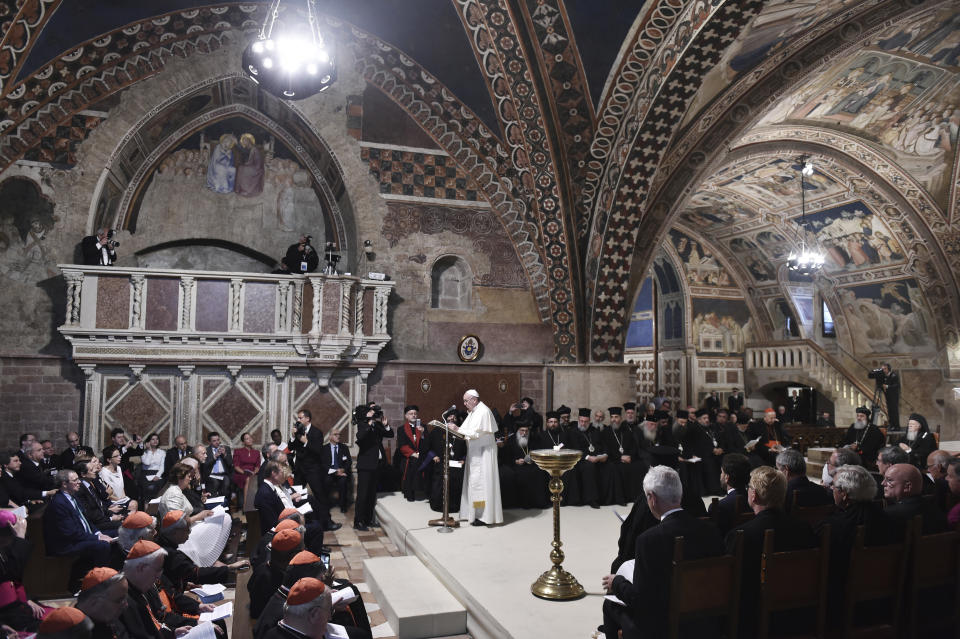 FILE - In this Tuesday, Sept. 20, 2016, Pope Francis, standing, leads a prayer with representatives of different religions, inside the Basilica of St. Francis, in Assisi, Italy. The Franciscan friars in Assisi say Pope Francis will journey there next month to sign a new encyclical, expected to stress the value of brotherly relations during and after the pandemic, in what could be his first visit outside of the Rome area since Italy went into lockdown. (Tiziana Fabi/Pool Photo via AP, File)