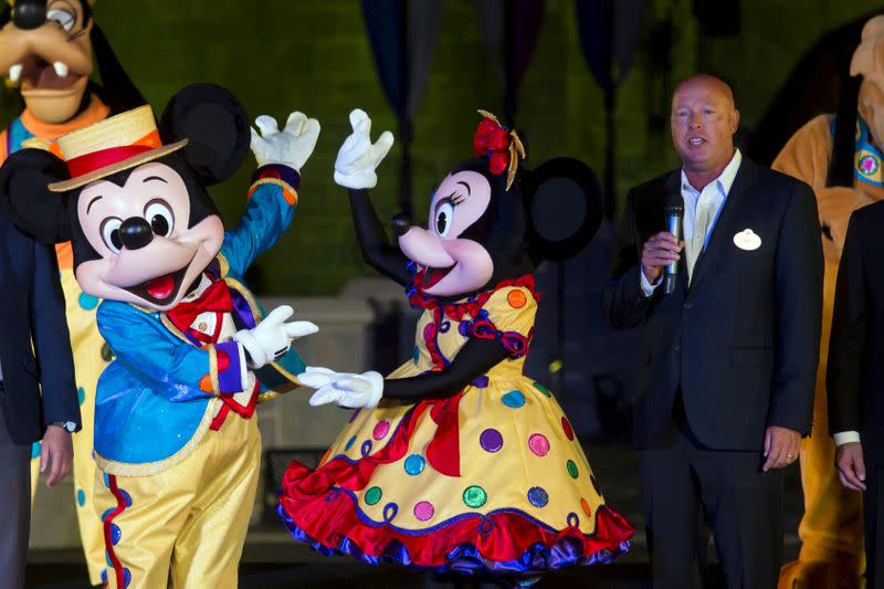 FILE PHOTO: Bob Chapek, chairman of Walt Disney Parks and Resorts, speaks next to Mickey Mouse and Minnie Mouse during the 10th anniversary ceremony of Hong Kong Disneyland in Hong Kong, China