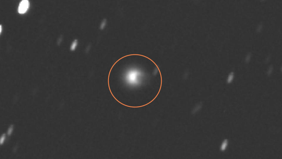 A zoomed out image of the comet with an orange circle around it