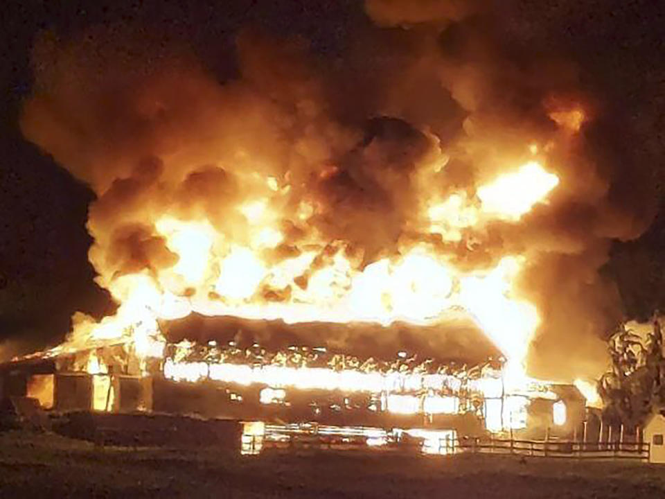 In this image provided by Deanna Raymond, a barn at Scamman Farm, in Stratham, N.H., is engulfed in flames late Monday, May 10, 2021. The fire destroyed the barn at the farm that's been the backdrop for political events for Republican presidents and candidates through the years. (Lucas Dawson via AP)