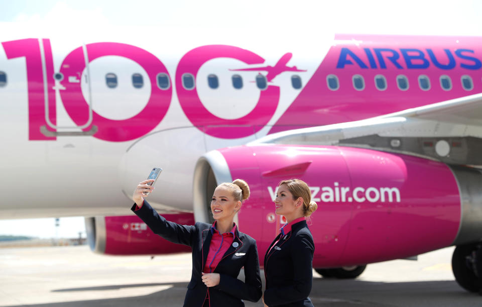 Stewardesses of Wizz Air take a selfie during the unveiling ceremony of the 100th plane of its fleet at Budapest Airport, Hungary, June 4, 2018. REUTERS/Bernadett Szabo