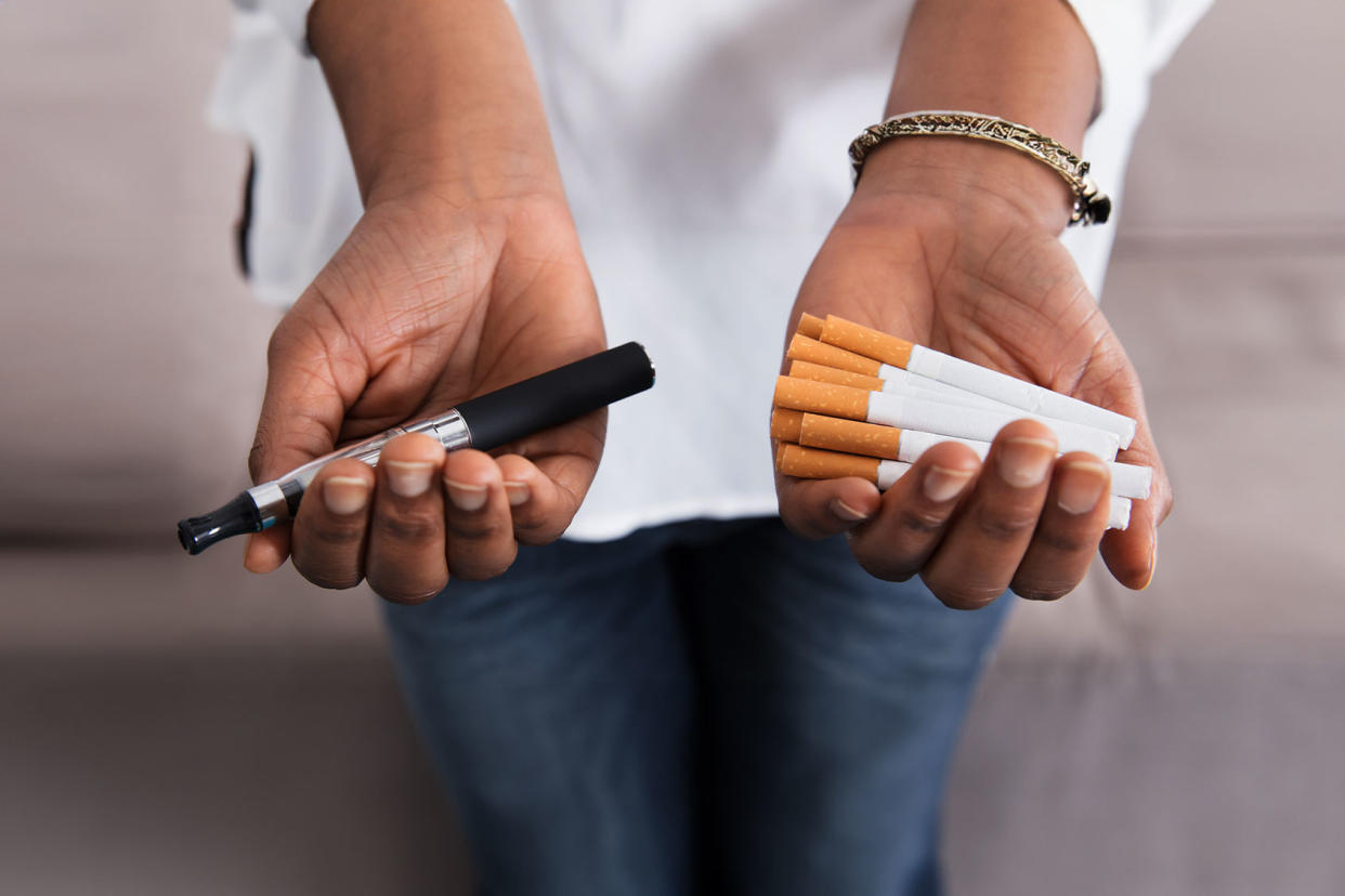 Hands holding vape and cigarettes Getty Images/AndreyPopov