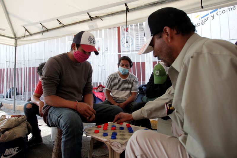 Un migrante hondureño (izq.), eue abandonó su país luego de los daños que dejaron los huracanes Eta e Iota, juega con otros migrantes en un refugio para migrantes en Guadalupe, México