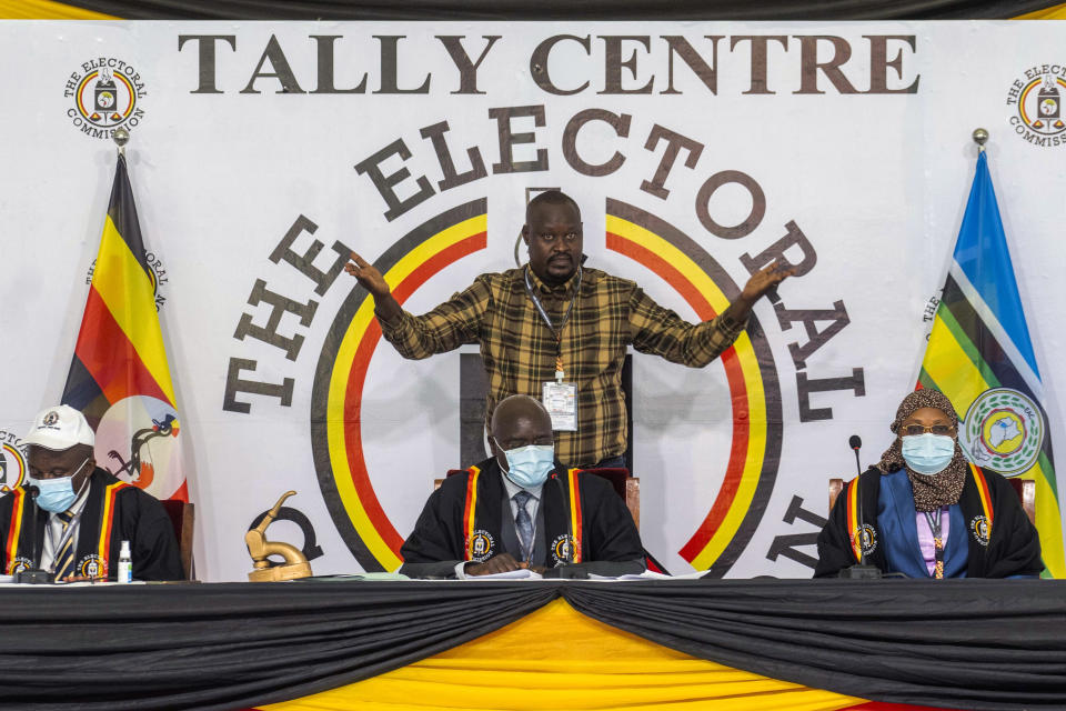 Uganda Electoral Commission chairman Simon Byabakama, seated center, declares Ugandan President Yoweri Kaguta Museveni winner of the presidential elections in Kampala, Uganda, Saturday Jan. 16, 2021. Uganda’s electoral commission says longtime President Yoweri Museveni has won a sixth term, while top opposition challenger Bobi Wine alleges rigging and officials struggle to explain how polling results were compiled amid an internet blackout. In a generational clash widely watched across the African continent, the young singer-turned-lawmaker Wine posed arguably the greatest challenge yet to Museveni. (AP Photo/Jerome Delay)