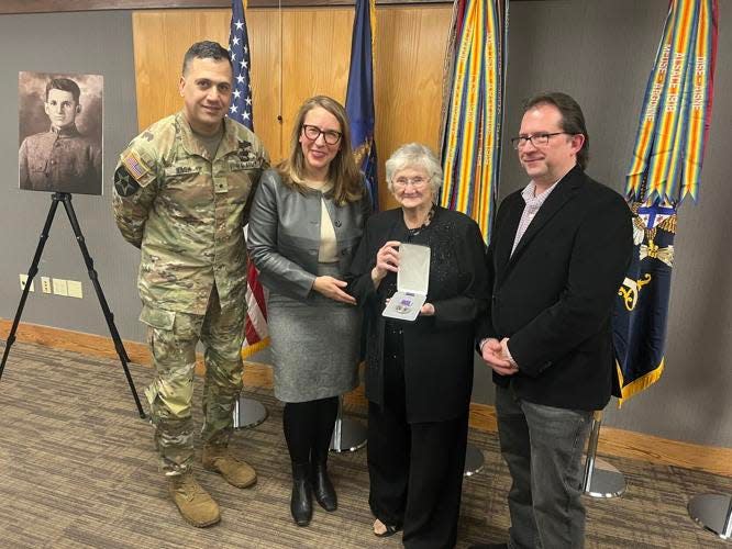 Verla Thomas holds a Purple Heart, awarded posthumously Friday, Jan. 5, to her father George Willis, pictured at left.