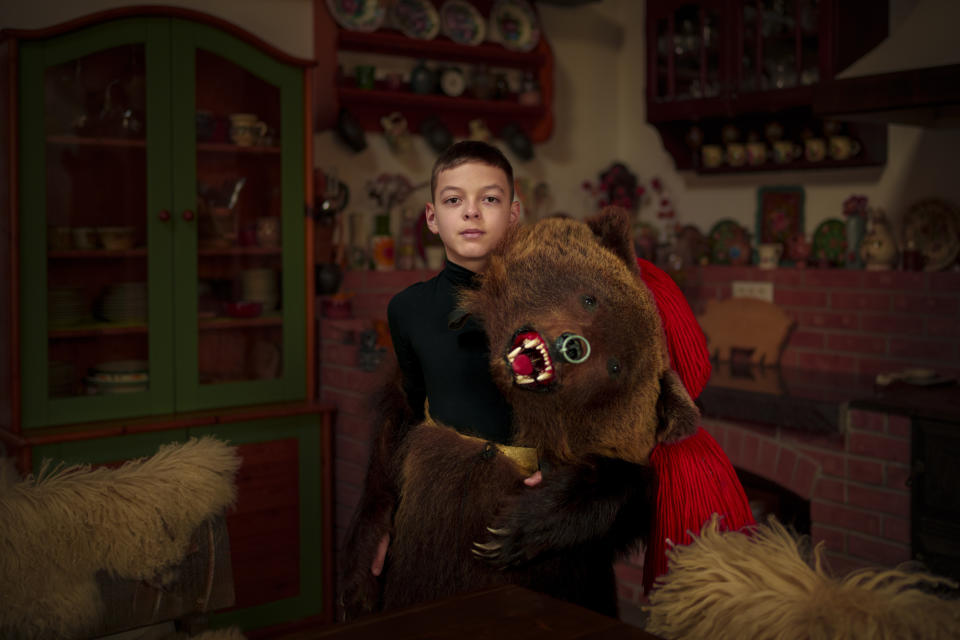 Costi, 11 years-old, a member of the Sipoteni bear pack, poses for a portrait in Comanesti, northern Romania, Wednesday, Dec. 27, 2023. Costi first wore the bear fur costume when he was 3 years-old, loves to dance and hear the pounding sound of drums. (AP Photo/Andreea Alexandru)
