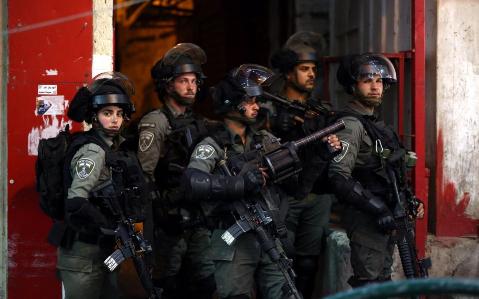 Israeli troops are seen during clashes with Palestinian protesters in the city center of the West Bank city of Hebron