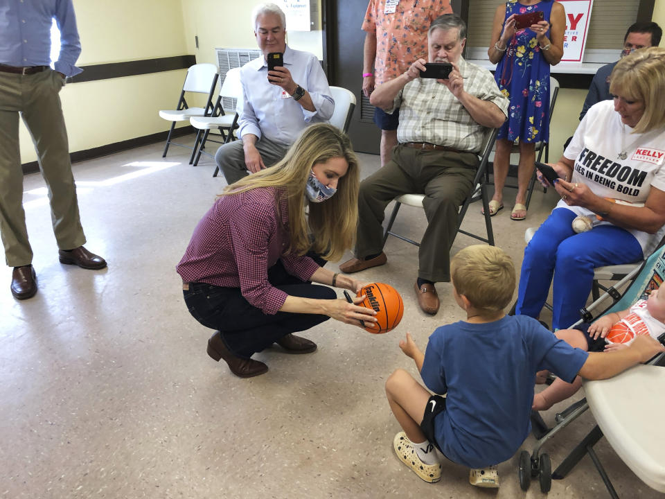 U.S. Sen Kelly Loeffler autographs a basketball, Thursday, Sept 3, 2020, at a campaign stop in Cumming, Ga. Two Black Lives Matter activists kept Loeffler from finishing a campaign speech. (AP Photo/Jeff Amy)