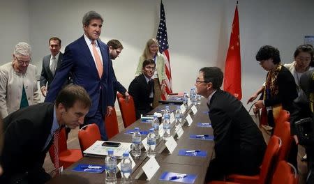 U.S. Secretary of State John Kerry (in red neck tie) takes his seat during a bilateral meeting with Chinese Deputy Minister For Environment Protection Zhai Qing to promote U.S. climate and environmental goals, at the Meeting of the Parties to the Montreal Protocol on the elimination of hydro fluorocarbons (HFCs) use in Rwanda's capital Kigali October 14, 2016. REUTERS/Cyril Ndegeya/Pool