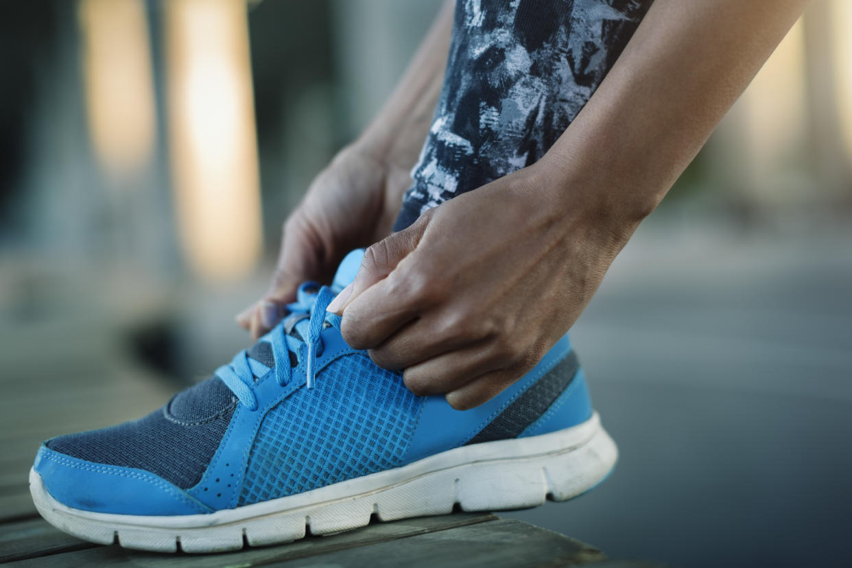 Close-up of woman tying shoelace on bench