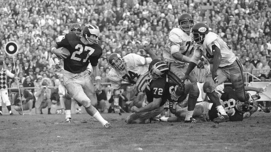 Don Moorhead runs around the right side of the line while offensive lineman Dan Dierdorf makes a key block.