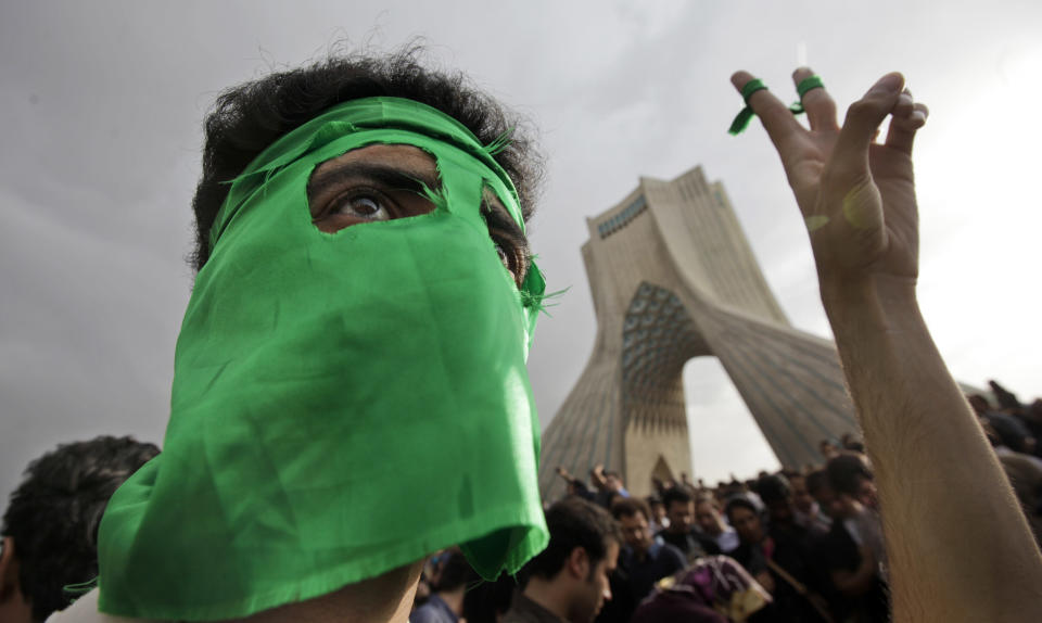 FILE - In this June 15, 2009, file photo, a demonstrator wears a green mask as hundreds of thousands of supporters of leading opposition presidential candidate Mir-Hossein Mousavi turn out to protest the result of the election in Azadi (Freedom) square in Tehran, Iran. Iran’s largest protests since its 1979 Islamic Revolution grew out of the disputed re-election of hard-line President Mahmoud Ahmadinejad. His reformist challenger, Mir-Hossein Mousavi, had picked green for his campaign urging changes within Iran’s theocracy. (AP Photo/Ben Curtis, File)