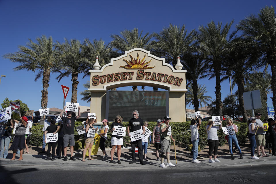 People protest Nevada's public mask mandate Wednesday, July 8, 2020, in Henderson, Nev. Nevada Gov. Steve Sisolak issued a mandatory face covering policy for public spaces throughout the state due to the coronavirus. (AP Photo/John Locher)