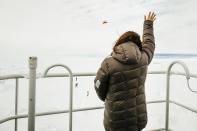 Nicole De Losa, a passenger on board the MV Akademik Shokalskiy waves to a helicopter sent from the Chinese icebreaker Xue Long (Snow Dragon) to assess ice conditions around the Russian Ship, in East Antarctica December 29, 2013, some 100 nautical miles (185 km) east of French Antarctic station Dumont D'Urville and about 1,500 nautical miles (2,800 km) south of Hobart, Tasmania. The Snow Dragon Chinese icebreaker was one of three icebreakers sent to free the MV Akademik Shokalskiy, which became stranded on Tuesday in ice driven by strong winds. Ice appeared to be cracking up on Sunday, raising hopes for a rescue as the Aurora Australis, a powerful Australian icebreaker, approached the stranded vessel. The trapped Russian ship, with 74 people on board, left New Zealand on November 28 on a privately funded expedition to commemorate the 100th anniversary of an Antarctic journey led by famed Australian explorer Douglas Mawson. REUTERS/Andrew Peacock (ANTARCTICA - Tags: ENVIRONMENT DISASTER) FOR EDITORIAL USE ONLY. NOT FOR SALE FOR MARKETING OR ADVERTISING CAMPAIGNS