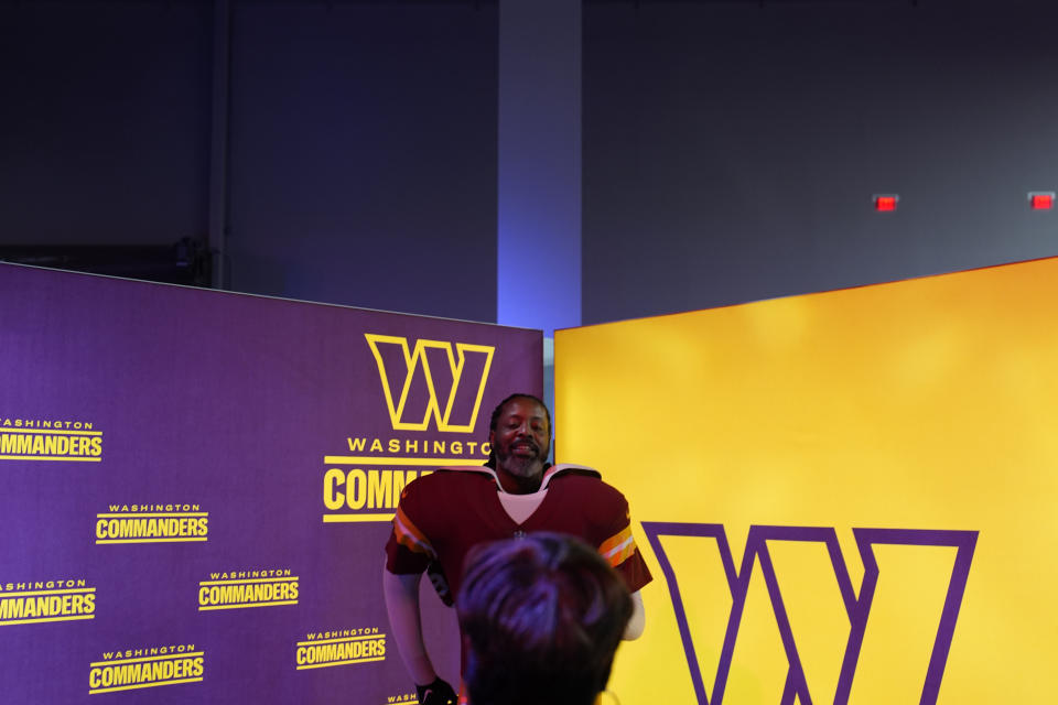 A fan poses at a Washington Commanders exhibit at the Super Bowl Experience ahead of the Super Bowl 58 NFL football game Wednesday, Feb. 7, 2024, in Las Vegas. (AP Photo/John Locher)