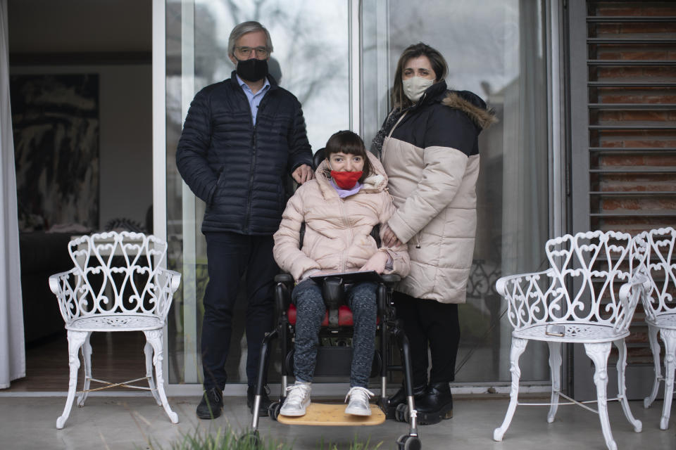 Husband and wife Francisco Da Giau and Lorena Torbidoni pose for a portrait with their 16-year-old daughter Milagros at their home in La Plata, Argentina, Wednesday, June 30, 2021. Milagros’ family is one of many who are asking the government to reach a deal with Pfizer in order to immunize children in Argentina who are at increased risk for severe illness from the virus. (AP Photo/Victor R. Caivano)