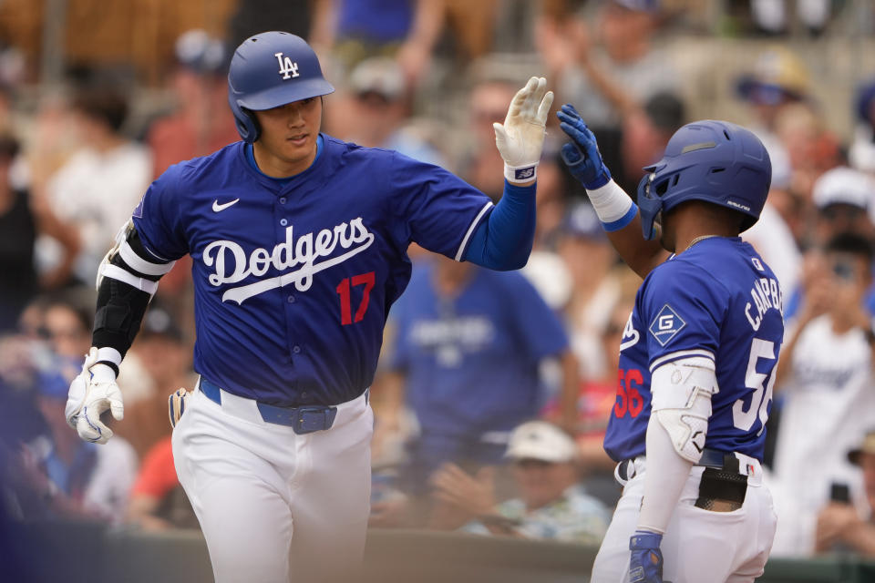 FILE - Los Angeles Dodgers designated hitter Shohei Ohtani greets Dylan Campbell, right, after hitting a two-run home run against the San Francisco Giants during the sixth inning of a spring training baseball game Tuesday, March 12, 2024, in Phoenix. (AP Photo/Lindsey Wasson, File)