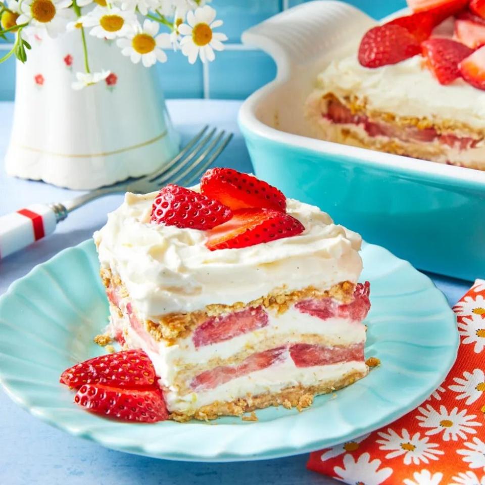 strawberry icebox cake slice on blue plate with flowers in back