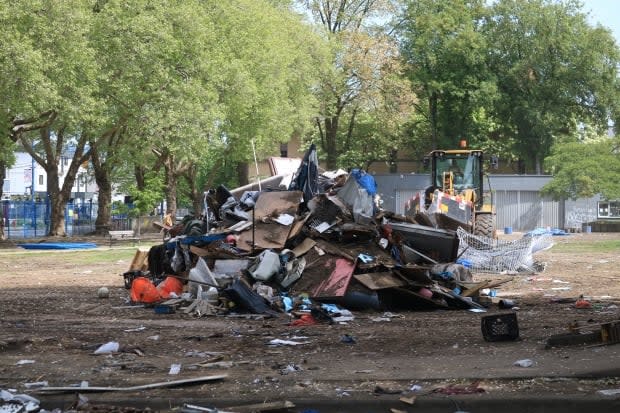 Crews remove debris from Oppenheimer Park in May 2020. As the pandemic took hold in B.C., officials forced park residents out, finding homes for many, while others found other places to go.