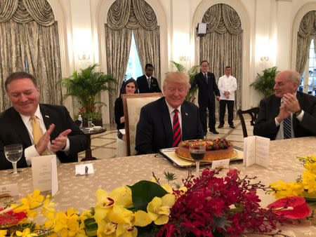 U.S. President Donald Trump smiles in front of a cake during an advanced birthday celebration at his meeting with Singapore's Prime Minister Lee Hsien Loong in the Istana, ahead of a summit between North Korea and the U.S., Singapore, June 11, 2018, in this photo obtained from social media. Vivian Balakrishnan's Twitter page/via REUTERS