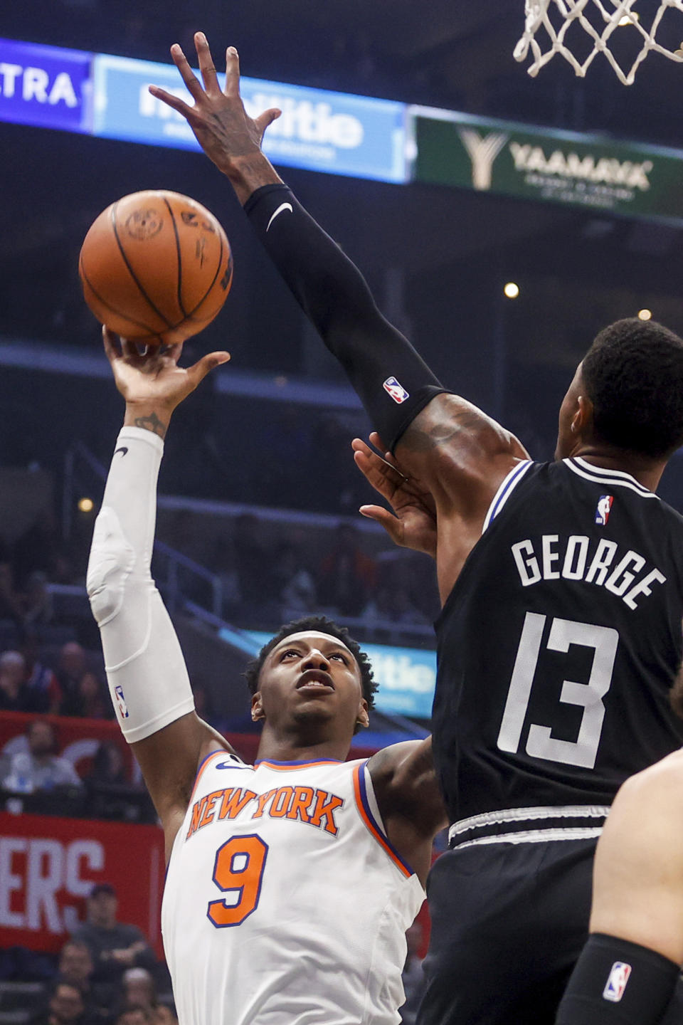 New York Knicks forward RJ Barrett, right, shoots against Los Angeles Clippers forward Paul George during the first half of an NBA basketball game Saturday, March 11, 2023, in Los Angeles. (AP Photo/Ringo H.W. Chiu)