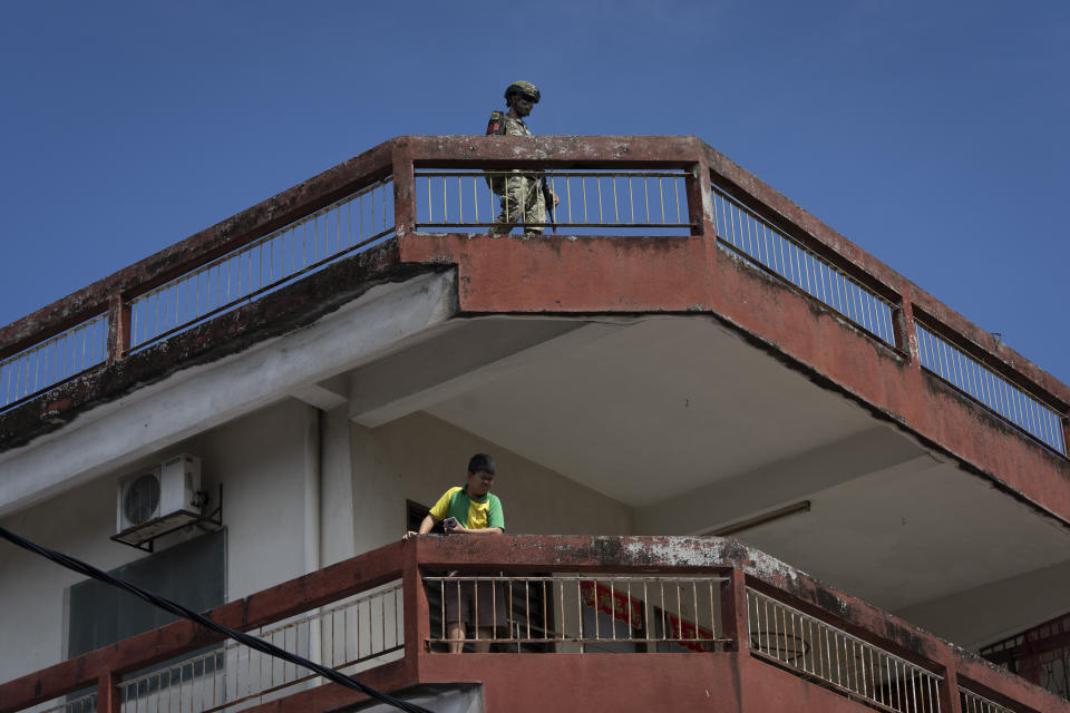 A soldier stands guard on the roof top of a residential building in the coronavirus lockdown area of Selayang Baru, in Kuala Lumpur, Malaysia, on Sunday, May 3, 2020. Malaysian Prime Minister Muhyiddin Yassin says the economy needs to be revived as billions have been lost during the partial lockdown that began in March. (AP Photo/Vincent Thian)