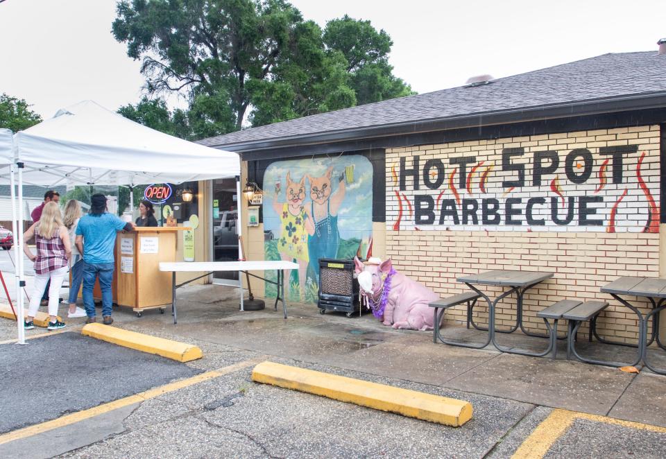 Customers place orders at Hot Spot Barbecue's makeshift to-go booth during the coronavirus pandemic in Pensacola on Wednesday, April 29, 2020.