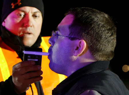 FILE PHOTO: Jefferson County Sheriff Deputy Kevin Schwindt tests a driver, whose face is illuminated by police car lights, to see if he is under the influence of drugs or alcohol, at a mobile Driving Under the Influence (DUI) checkpoint in Golden, Colorado, U.S. on April 12, 2008. REUTERS/Rick Wilking/File Photo