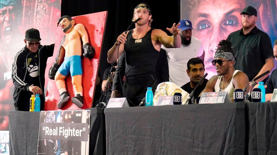 Paul brings a cake mimicking Danis, his opponent on October 14, onto stage during a press conference. - Jonathan Brady/AP