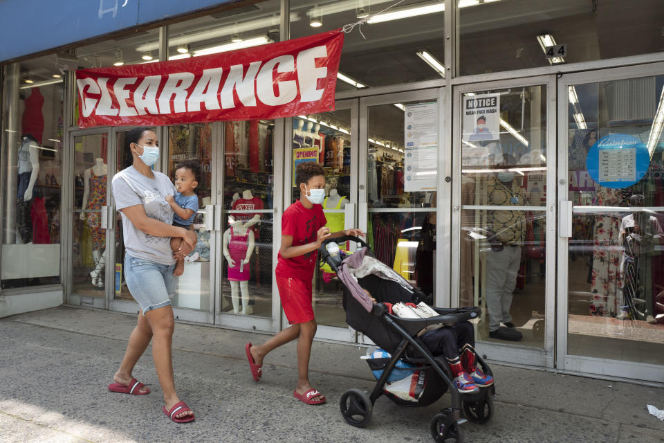 People walk by Rainbow clothing store, Tuesday, June 9, 2020, in Mount Vernon, N.Y. Counties north of New York City are reopening clothing stores as part of Phase 2 during the coronavirus pandemic. (AP Photo/Mark Lennihan)