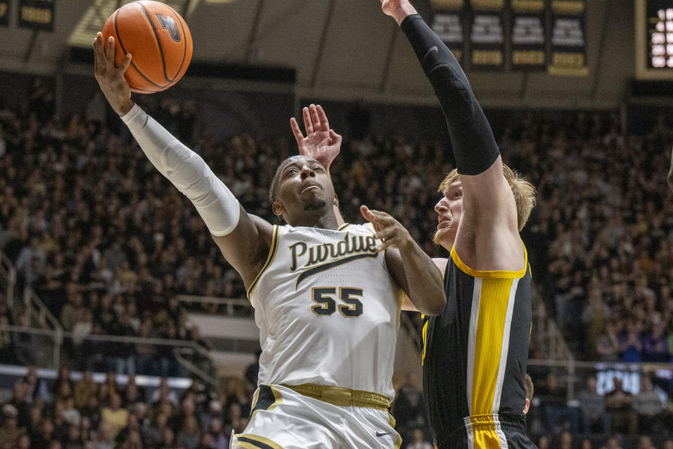 Purdue guard Lance Jones (55) shoots while being defended by Iowa center Even Brauns, right, during the second half of an NCAA college basketball game, Monday, Dec. 4, 2023, in West Lafayette, Ind. (AP Photo/Doug McSchooler)
