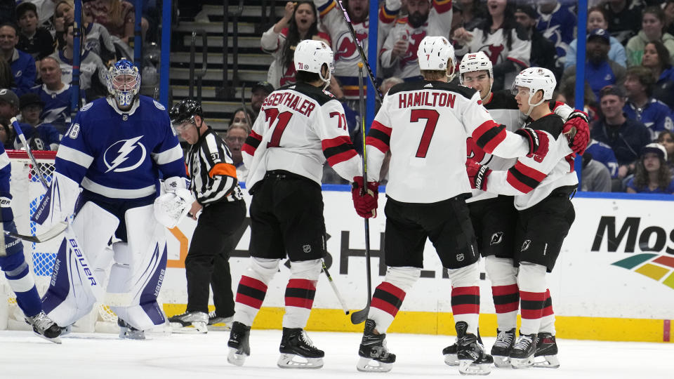 New Jersey Devils left wing Jesper Bratt, (63, right) celebrates with teammates, including defenseman Dougie Hamilton (7) and defenseman Jonas Siegenthaler (71) after scoring past Tampa Bay Lightning goaltender Andrei Vasilevskiy (88) during the.second period of an NHL hockey game Sunday, March 19, 2023, in Tampa, Fla. (AP Photo/Chris O'Meara)