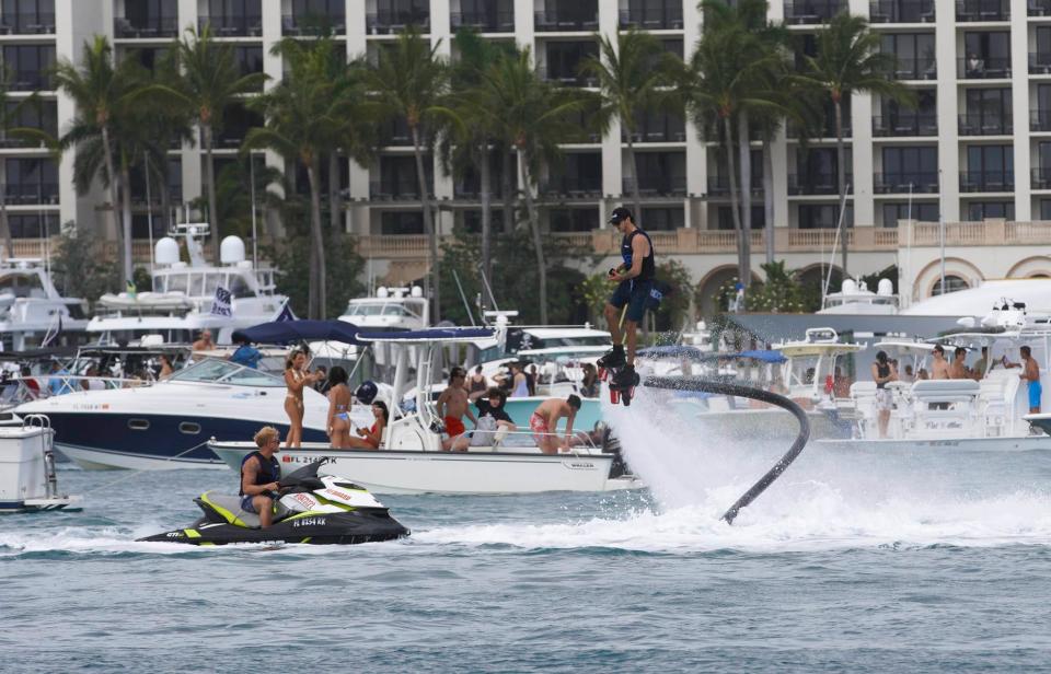 A man in a jet pack is seen taking video of hundreds of people boating, dancing, and drinking during Boca Bash Sunday, April 28, 2024 in Lake Boca in Boca Raton.