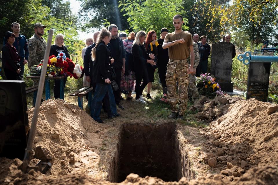 A Ukrainian soldier Pavlo "Zhulik" Sazonov, right, says good-bye to his comrade Andrii "Adam" Grinchenko of the 3rd Assault Brigade, who was injured in the battle for Andriivka, during funeral ceremony at the cemetery in Shostka, Sumy region, Ukraine, Tuesday, Sept. 26, 2023. Andrii's soldier friends came to pay their respects. Soldier of 3rd Assault Brigade Nom du Guerre "Zhulik" remembers the day when his commander Andrii was injured. It was Sept. 6, and they fought for Andriivka in the Donetsk region. "Zhulik" said it was difficult battle and then Andrii helped to evacuate a lot of soldiers and saved their lives.