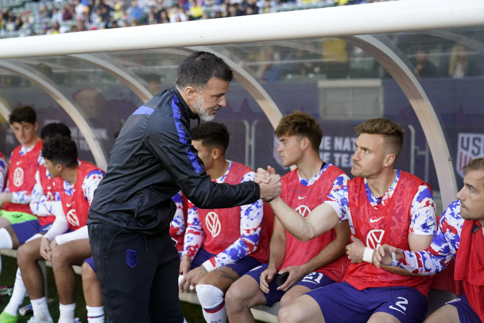 U.S. coach Anthony Hudson shakes hands with players on the bench before the team's international friendly soccer match against Colombia on Saturday, Jan. 28, 2023, in Carson, Calif. (AP Photo/Marcio Jose Sanchez)