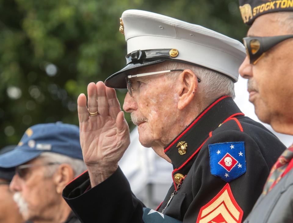 WWII Marine veteran 96-year-old Sgt. Frank Wright salutes at the Village Barbershop Veterans Day observance at Lincoln Center in Stockton, CA.