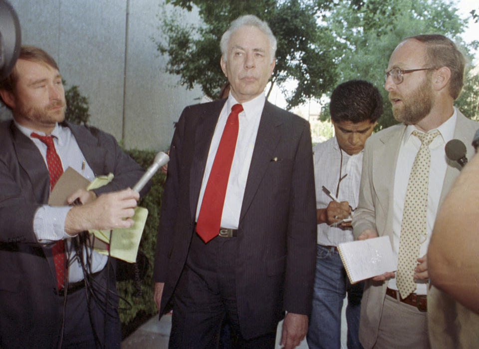 FILE - In this 1990 file photo, former Associated Press Reporter Steve Lawrence, right, questions former State Sen. Paul Carpenter, center, as he leaves the federal courthouse in Sacramento, Calif. Lawrence, a California government reporter who covered a major capital corruption scandal and governors ranging from Ronald Reagan to Arnold Schwarzenegger during a nearly four-decade career with The Associated Press, died Friday, Feb. 22, 2019. His wife, Jane, said he had been battling cancer and had been in the intensive care unit at Sutter Medical Center in Sacramento for about three weeks. He was 71. (AP Photo/Rich Pedroncell, File)