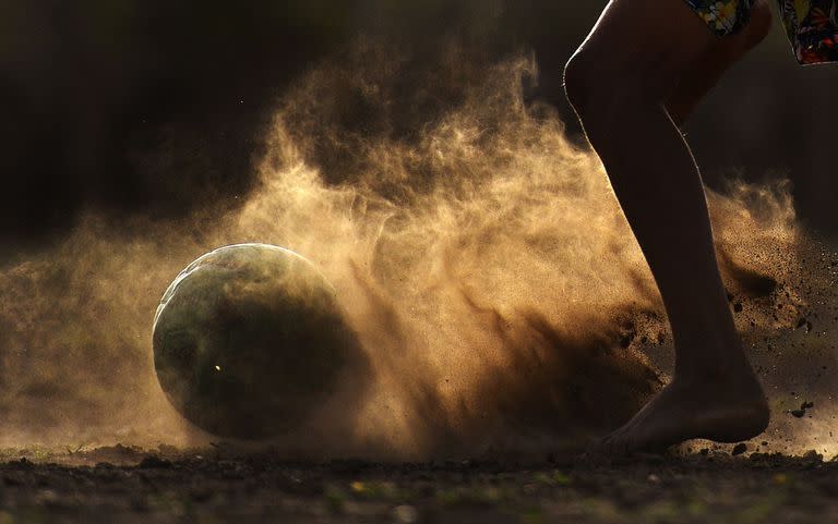 Un niño juega fútbol en una cancha polvorienta en Barrancas, provincia de la Guajira, Colombia, el 22 de mayo de 2022