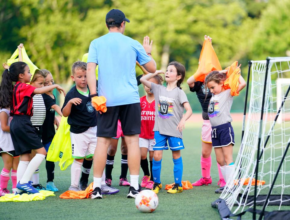 Gotham FC goalkeeper coach Brody Sams high-fives players during a youth soccer clinic at Brookdale Park soccer field in Montclair on Monday, June 13, 2022. 