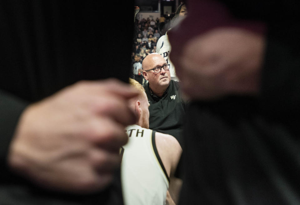 Wake Forest head coach Steve Forbes huddles together with his team during a timeout in the first half of an NCAA college basketball game against Appalachian State on Wednesday, Dec. 14, 2022, at Joel Coliseum in Winston-Salem, N.C. (Allison Lee Isley/The Winston-Salem Journal via AP)