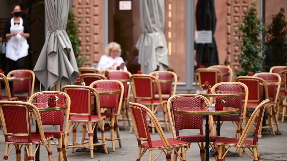 Viele freie Tische vor einem Café in Frankfurt.