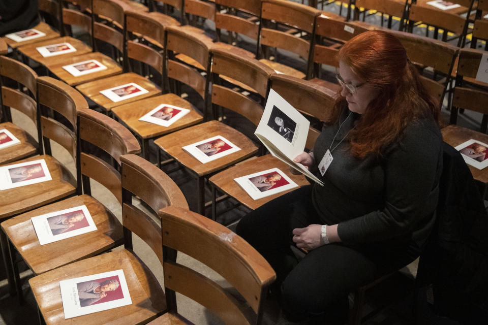 A woman looks through the program before the start of the Celebration of the Life of Toni Morrison, Thursday, Nov. 21, 2019, at the Cathedral of St. John the Divine in New York. (AP Photo/Mary Altaffer)